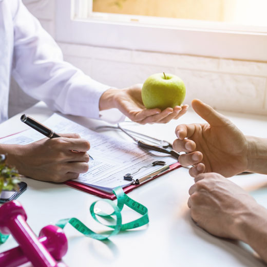 A visual representation of a mother engaged in a nutritious activity, cutting fruits as part of a balanced diet, at Aura Birthing Partner's Nutrition and Diet Consultation.